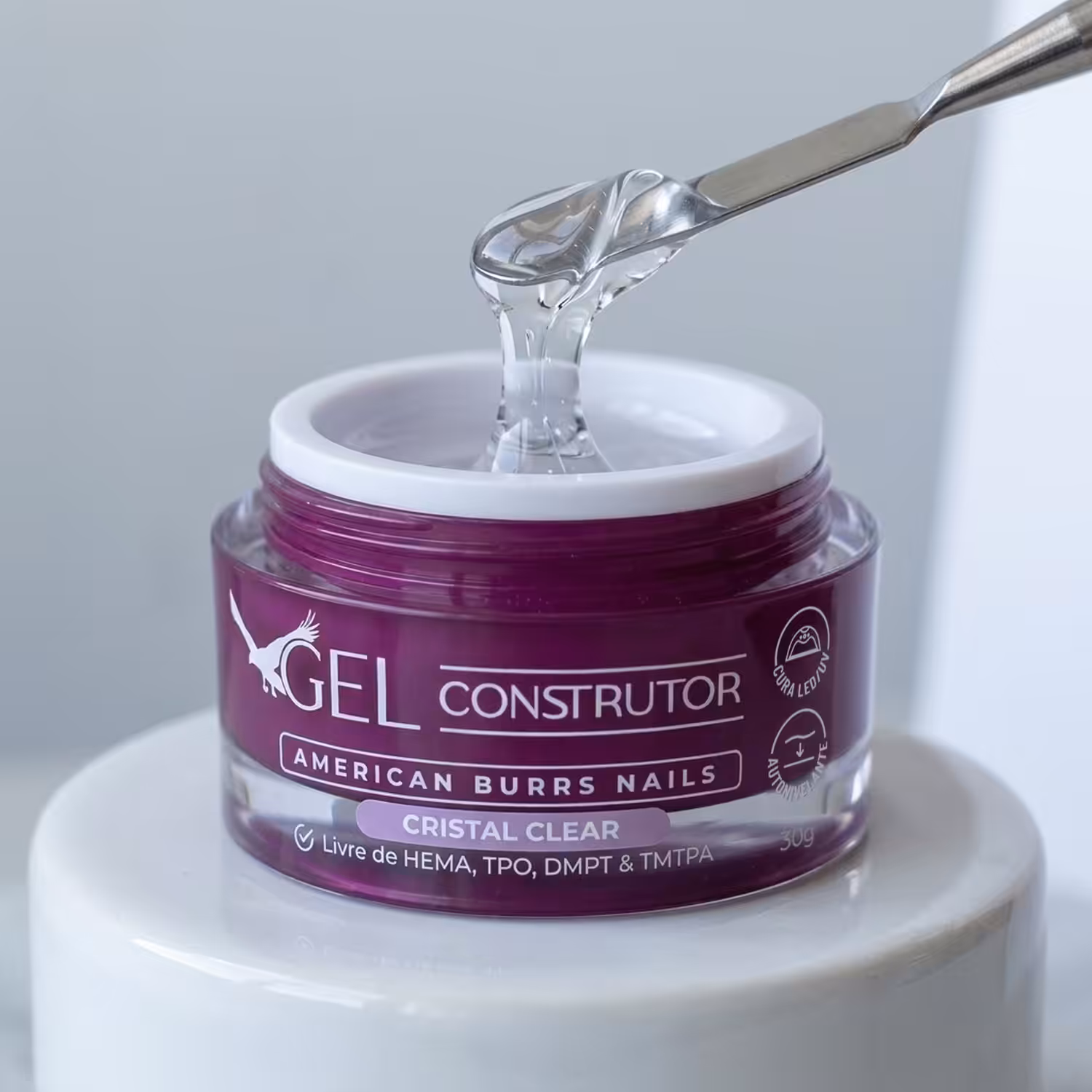 Espátula puxando o Gel Construtor Cristal Clear do pote aberto