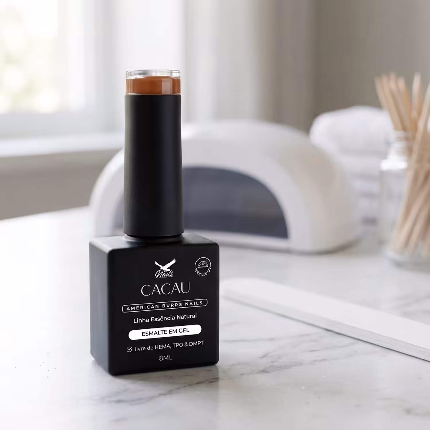 Frasco do Esmalte em Gel Cacau, da Linha Essência Natural, sobre uma bancada de mármore