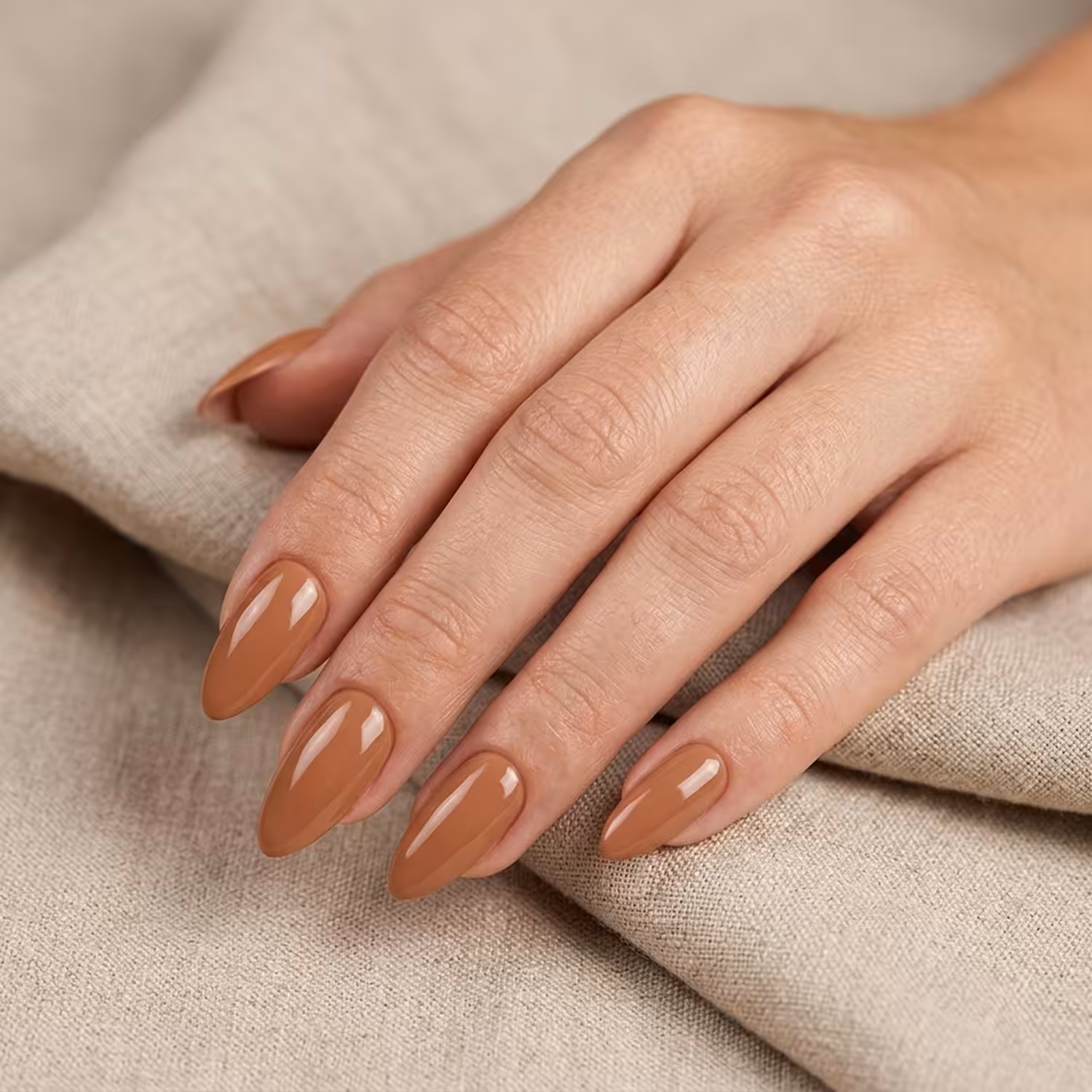 Mão com unhas pintadas com o Esmalte em Gel Cacau, da Linha Essência Natural