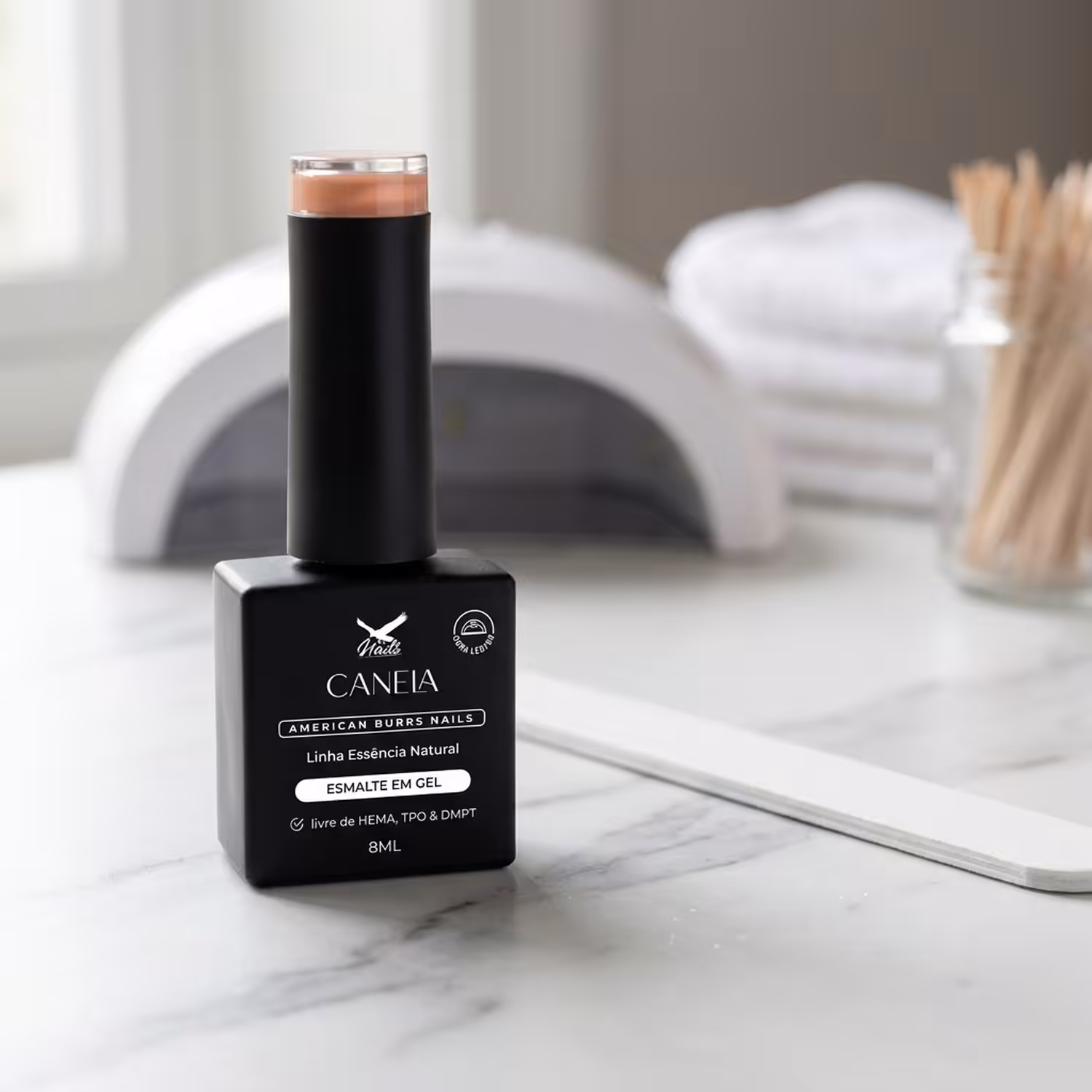 Frasco do Esmalte em Gel Canela, da Linha Essência Natural, sobre uma bancada de mármore