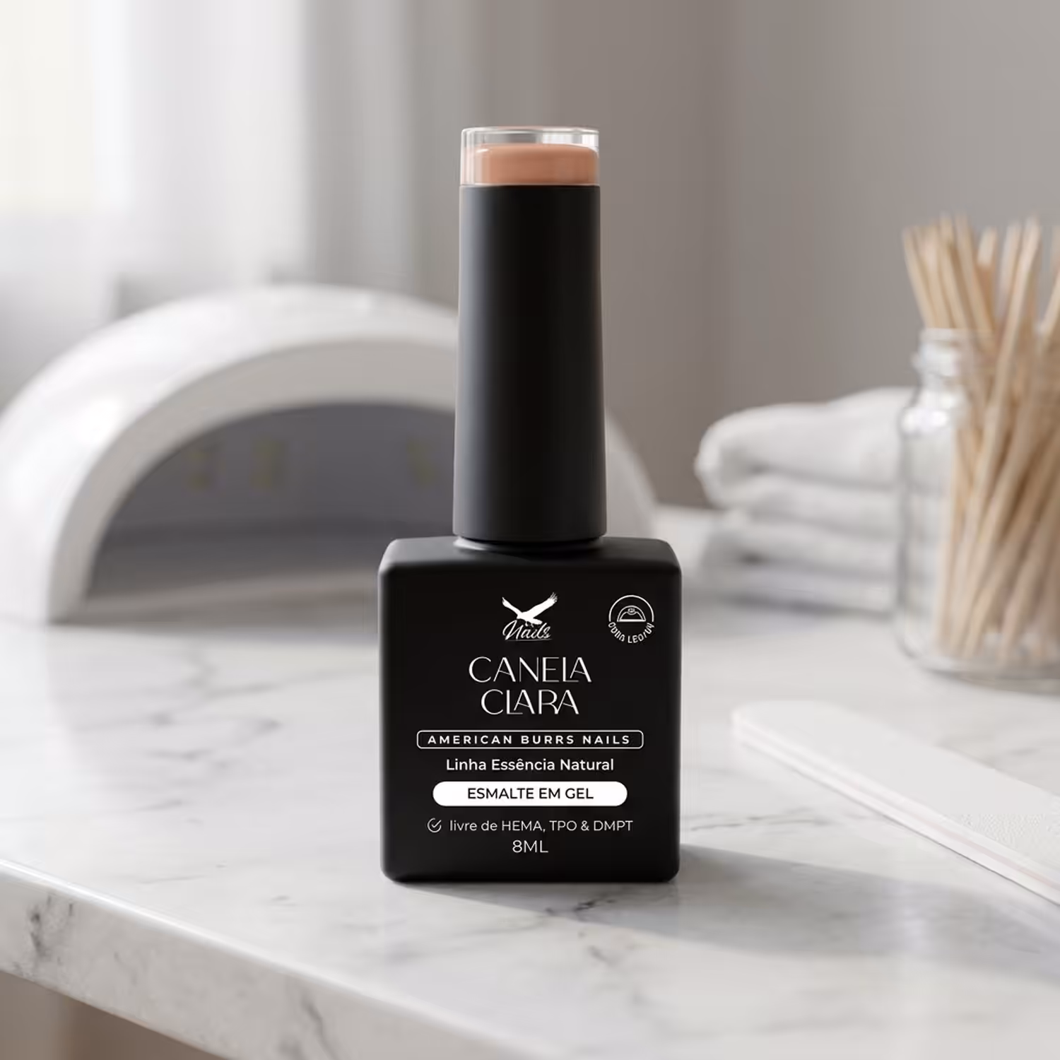 Frasco do Esmalte em Gel Canela Clara, da Linha Essência Natural, sobre uma bancada de mármore